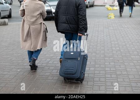 KIEW, UKRAINE - 27. Sep 2019: Straßenszene in Kiew, der Hauptstadt der Ukraine. Ein Mann schleppt einen Koffer auf Rädern auf den Straßen von Kiew Stockfoto