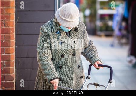 Eine nicht erkennbare ältere Frau, die beim Einkaufen eine Gesichtsmaske trägt Am Walthamstow Markt in London Stockfoto