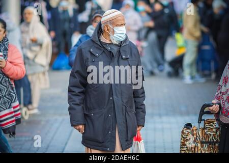 London, Großbritannien - 3. November 2020 - ein asiatischer Muslim, der beim Einkaufen auf dem Walthamstow Markt eine Maske trägt Stockfoto