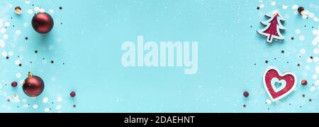 Weihnachtskomposition mit roten und weißen Dekorationen auf pastellblauer Oberfläche, Draufsicht, Kopierraum. Frohe Weihnachten und frohe Feiertage Grußkarte Stockfoto