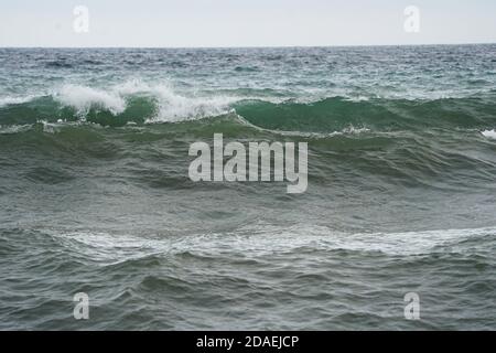 Brechende Wellen an der Küste an einem bewölkten Tag, Andalusien, Spanien. Stockfoto