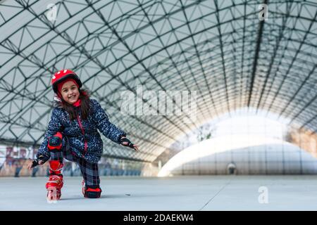 Kleines Mädchen Rollerblading auf Rollbahn Stockfoto