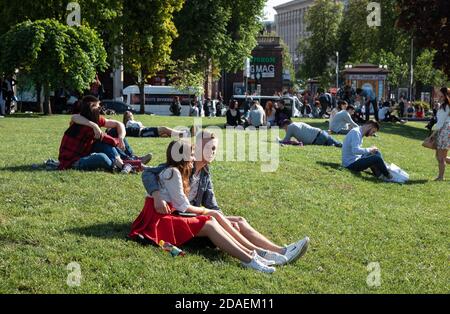 KIEW, UKRAINE - 04. Mai 2017: Junge Menschen ruhen sich an einem sonnigen Frühlingstag auf dem grünen Rasen aus. Die Bürger ruhen sich auf dem Rasen am Independence Squar aus Stockfoto