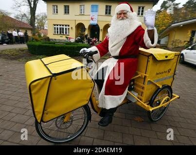 Himmelpfort, Deutschland. November 2020. Der Weihnachtsmann kommt mit einem Elektrofahrrad der Deutschen Post in Himmelpfort an. Bis Heiligabend wird er mit Unterstützung seiner 20 fleißigen Helfer die Kinderbriefe aus Deutschland und der ganzen Welt wieder beantworten. Aufgrund der anhaltenden Gefahr einer Coronainfektion wird es in diesem Jahr leider keine öffentlich zugängliche Weihnachtspost geben und der Weihnachtsmann und seine Engel können im Weihnachtsdorf nicht besucht werden. Quelle: dpa picture Alliance/Alamy Live News Stockfoto