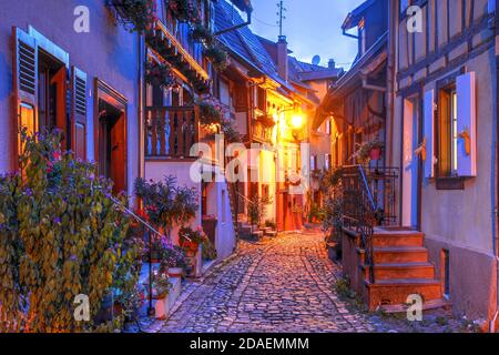 Nachtszene in den charmanten Straßen von Eguisheim, einem typischen Dorf in der elsässischen Weinregion von Frankreich. Stockfoto