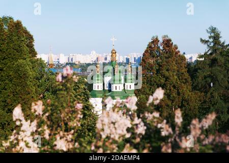 Kiewer Landschaften. Frühlingsansicht des Vydubychi-Klosters und des Flusses Dnipro mit rosa und weißen Fliederblüten im botanischen Garten in Kiew-Stadt, Ukraine Stockfoto