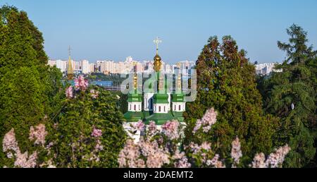 Kiewer Landschaften. Frühlingsansicht des Vydubychi-Klosters und des Flusses Dnipro mit rosa und weißen Fliederblüten im botanischen Garten in Kiew-Stadt, Ukraine Stockfoto