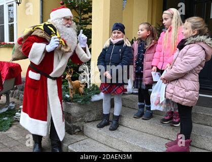 Himmelpfort, Deutschland. November 2020. Kinder aus der Grundschule begrüßen den Weihnachtsmann im Himmelpfort. Bis Heiligabend wird er mit Unterstützung seiner 20 fleißigen Helfer die Kinderbriefe aus Deutschland und der ganzen Welt wieder beantworten. Aufgrund der anhaltenden Gefahr einer Coronainfektion wird es in diesem Jahr leider keine öffentlich zugängliche Weihnachtspost geben und der Weihnachtsmann und seine Engel können im Weihnachtsdorf nicht besucht werden. Quelle: dpa picture Alliance/Alamy Live News Stockfoto