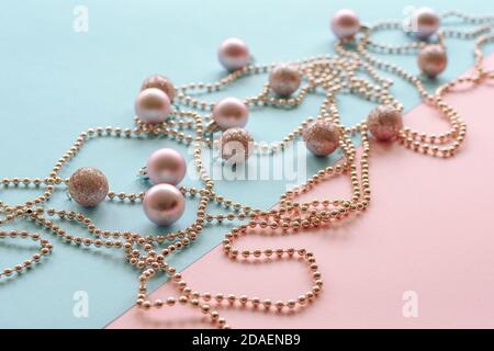 Weihnachtskugeln und Girlande auf blauem und rosa Hintergrund, Neujahrskonzept. Draufsicht. Stockfoto