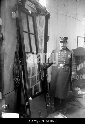 Porträt eines männlichen Polizisten, der neben einer Tür des Iroquois Theatre, Chicago, Illinois, steht, 30. Dezember 1903. Stockfoto