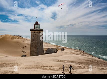 Der Leuchtturm rubjerg knude fyr an der dänischen Küste versinkt im Sand. Ein Gleitschirm ist über dem Leuchtturm zu sehen. Stockfoto