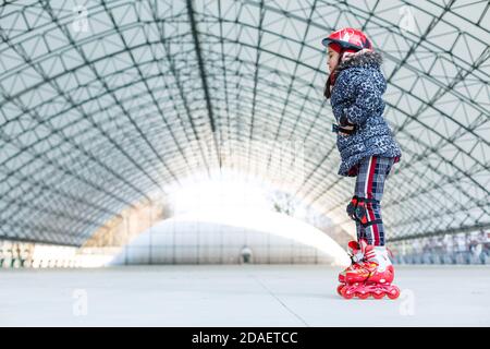 Kleines Mädchen Rollerblading auf Rollbahn Stockfoto