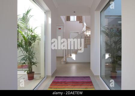 Flur in modernen Haus mit Treppen am Ende und Fenster aus Glas zu den Innenhöfen an der Seite Stockfoto