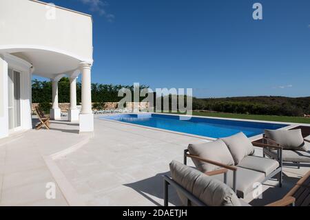 Großer Swimmingpool im Garten einer Luxusvilla An der algarve mit keramischen Fliesen und Sitzbereich Stockfoto