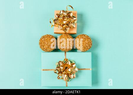 Weihnachtskomposition mit Geschenkschachteln und goldenen Weihnachtskugeln auf blauem Hintergrund, flach liegend. Stockfoto