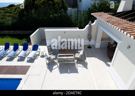 Man hat einen schönen Blick auf den Sitzbereich der Terrasse Pool im Garten einer Ferienvilla Stockfoto