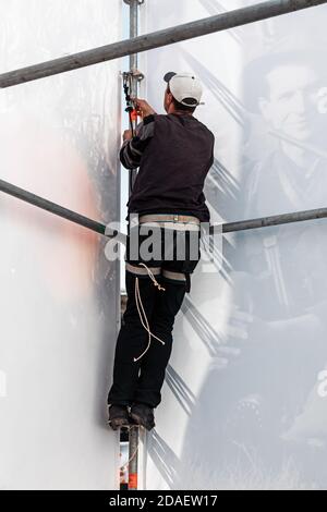 KIEW, UKRAINE - 05. Mai 2017: Arbeiter bereitet Plakat für die Installation neuer Werbung auf dem Unabhängigkeitsplatz in Kiew. Stockfoto