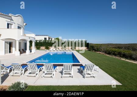 Großer Swimmingpool im Garten einer Luxusvilla An der algarve mit einer Reihe von Sonnenliegen Stockfoto