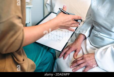 Ärztin Ausfüllen eines Fragebogens Stockfoto