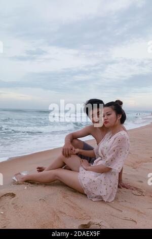 Vertikale Aufnahme eines glücklichen Paares in einem Meer, Vung Tau Stockfoto