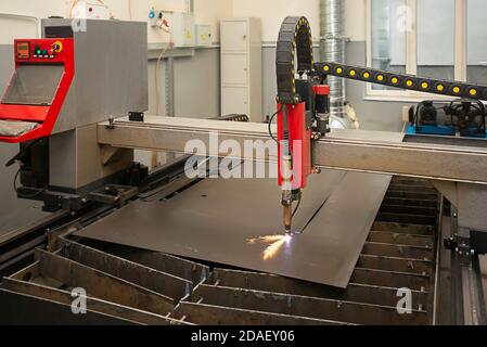 Industrielle Laser-oder Plasmaschneiden Verarbeitung Herstellung Technologie von Flachblech. Stahlmaterial mit Funken Stockfoto
