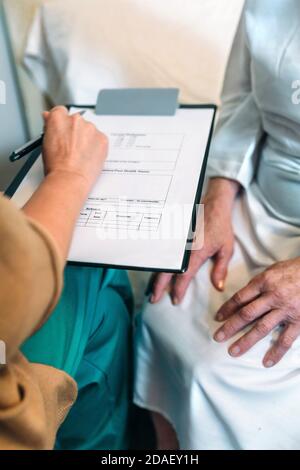 Ärztin Ausfüllen eines Fragebogens Stockfoto