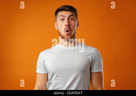 Erstaunt und verwirrt bärtiger junger Mann sieht erstaunt aus. Stockfoto
