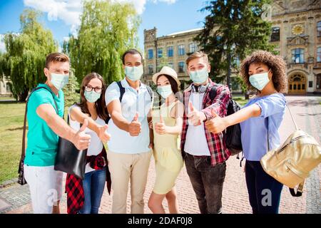 Foto Porträt von sechs Personen zeigt Daumen nach oben tragen Gesicht Masken in der Nähe der Universität Stockfoto