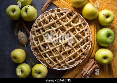 Apfelkuchen auf gelbem Stoffhintergrund. Schön dekorierte Torte Draufsicht Foto. Hausgemachter Dessertkuchen. Stockfoto