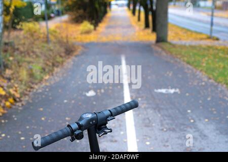 Roller auf dem Hintergrund der Straße, die Linien am Horizont konvergieren. Herbstzeit . Pflügen, gelbes Laub von den Bäumen. Hochwertige Fotos Stockfoto