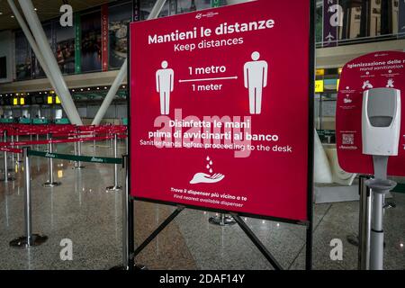 Schild am Flughafen Olbia in Sardinien, Italien, erinnert die Passagiere an soziale Distanz und desinfizieren Hände während der Coronavirus-Krise in Italien. Stockfoto