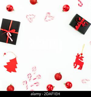 Weihnachtsrahmen Komposition. Geschenke, Baumschmuck und Zuckerstöcke auf weißem Hintergrund. Flach liegend, Draufsicht. Stockfoto