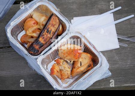 Lieferung von Lebensmitteln. Verschiedene Aluminium-Lunchbox mit Hühnerfilet, Kartoffeln und gegrillter Aubergine. Essen zum Mitnehmen, Blick von oben. Stockfoto