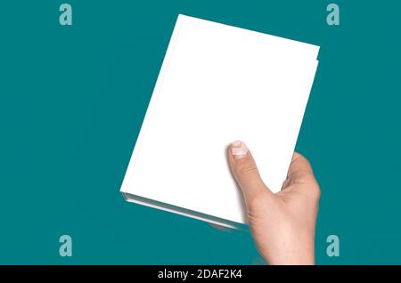 Ein Modell eines weißen geschlossenen Buches mit einem Platz Für Text in einer Hand Stockfoto