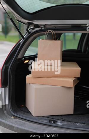 Pakete in Boxen im Auto im Freien. Take-out-Konzept. Online-Shopping. Mock up. Service Coronavirus. Stockfoto