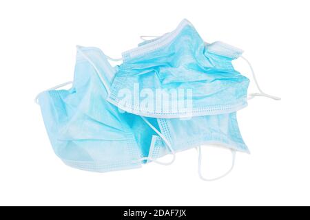Weggeworfene gebrauchte Gesichtsmasken auf weißem Hintergrund Stockfoto