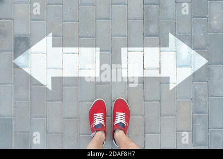 Ein Mann in roten Turnschuhen hielt vor den Blinkern. Entscheidungskonzept. Stockfoto