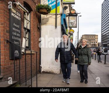 Ein altes Paar geht an der Zirkusstube, Portland Street, manchester vorbei Stockfoto