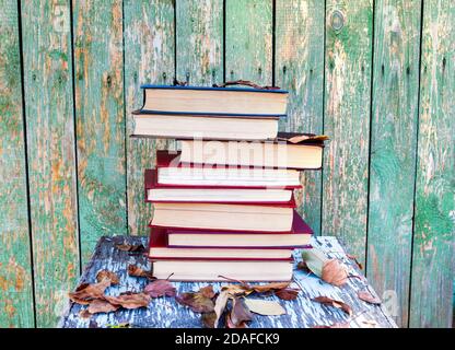 Stapel von Büchern auf den alten Planken Hintergrund draußen Stockfoto