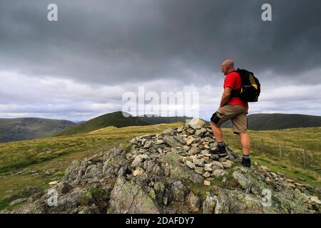 Walker at the Summit Cairn of Yoke Fell, Hartsop Valley, Kirkstone Pass, Lake District National Park, Cumbria, England, UK Yoke Fell ist einer der 214 Stockfoto