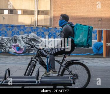 Glasgow, Schottland, Großbritannien. November 2020. Wetter in Großbritannien. Ein Deliveroo Fahrradkurier, der in der Sauchiehall Street eine Pause einnimmt. Kredit: Skully/Alamy Live Nachrichten Stockfoto