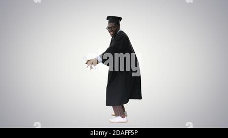 Aufgeregt afroamerikanischen männlichen Schüler in Graduation Robe tanzen Stockfoto