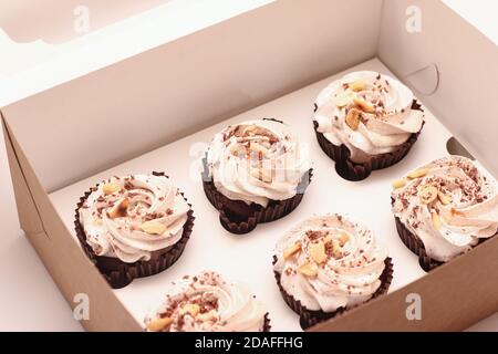 Sechs Schokoladen-Brownies mit weißer Creme auf einem weißen Teller. Studio-Foto in einem Winkel Stockfoto