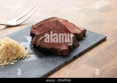 Picanha Fleisch, brasilianisches Kuhsteak, serviert mit Farofa an einem Holztisch Stockfoto