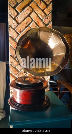 Gramophone mit Platte oder Vinyl-Scheibe. Plattenspieler aus antikem Messing. Gramophone mit Hornlautsprecher. Vertikal Stockfoto