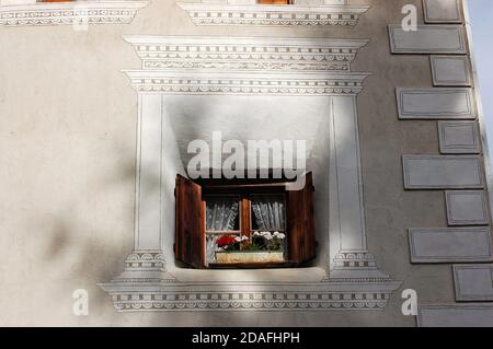 Fenster mit Topfblumen und Dekorationen im alten Dorf Ardez, Gemeinde Scuol, Engadin, Kanton Graubünden, Schweiz, Europa Stockfoto