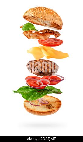 Maxi Burger Zubereitung mit fliegenden Zutaten isoliert auf weißem Hintergrund. Beschneidungspfad Stockfoto