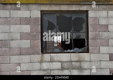 Kaputte Fenster an einer Ziegelwand Stockfoto