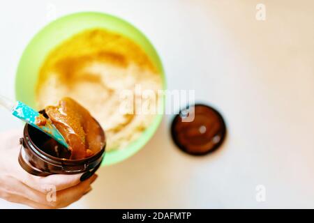 Der Konditor fügt der gemahlenen Leber Sahne hinzu. Süßer Pie-Teig. Background. Zutaten für süßen Kuchen mischen. Kochen klassischen Käsekuchen. Stockfoto