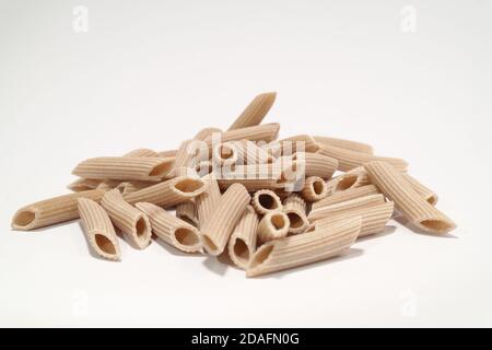 Penne aus Vollkornbrot hergestellt aus Dinkelmehl auf dem weißen Hintergrund, ist Penne ideal für Tomaten und Mozarella-Sauce. Stockfoto